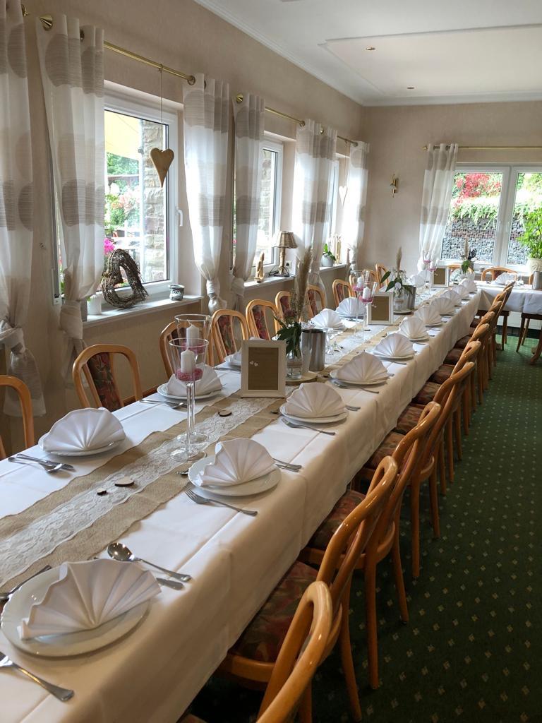 Hell eingedeckte Festtafel im Landhaus Schend mit weißen Serviettenfächern bei Tageslicht
